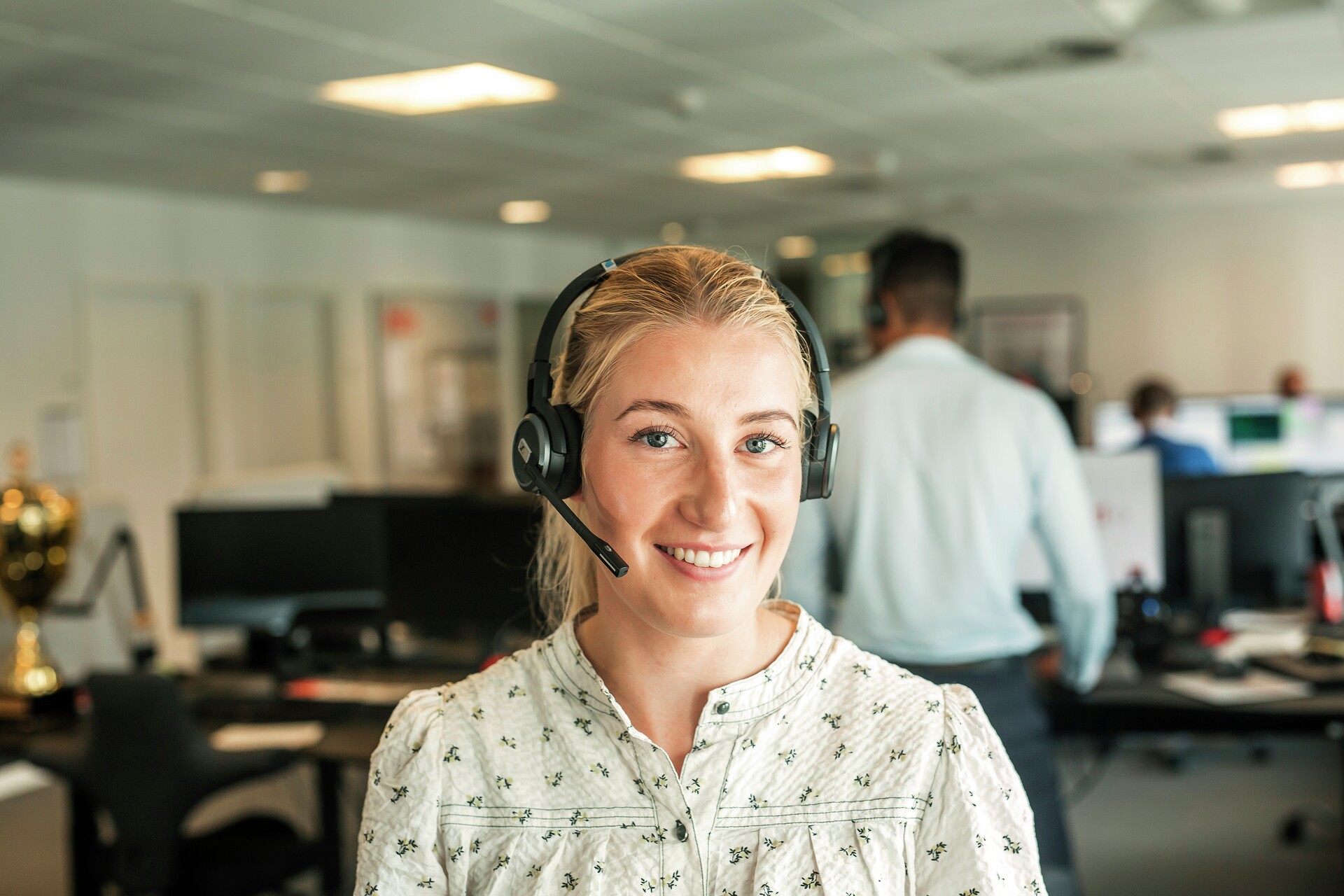 Kvinde har headset på og smiler