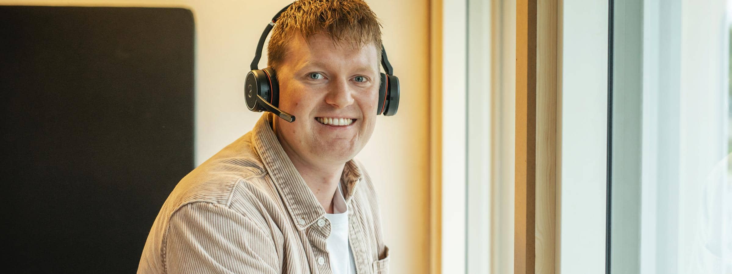 Ung mand sidder med headset på