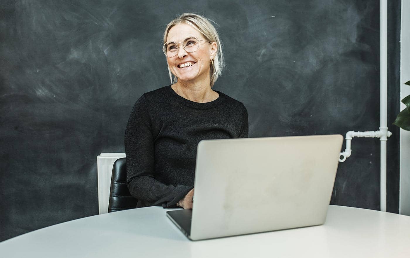 Billede af kvinde med computer som griner