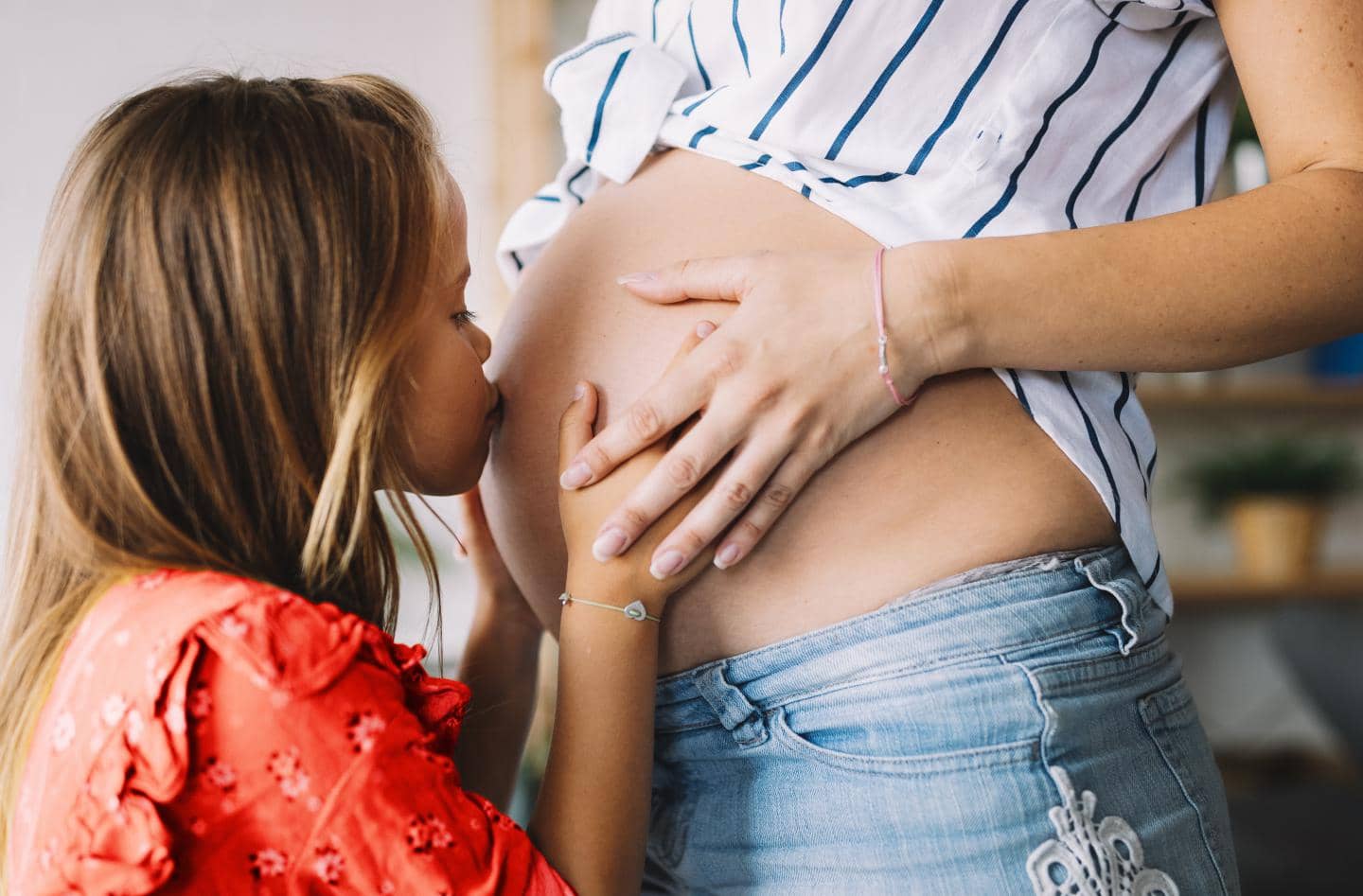Barn kysser gravid kvindes mave